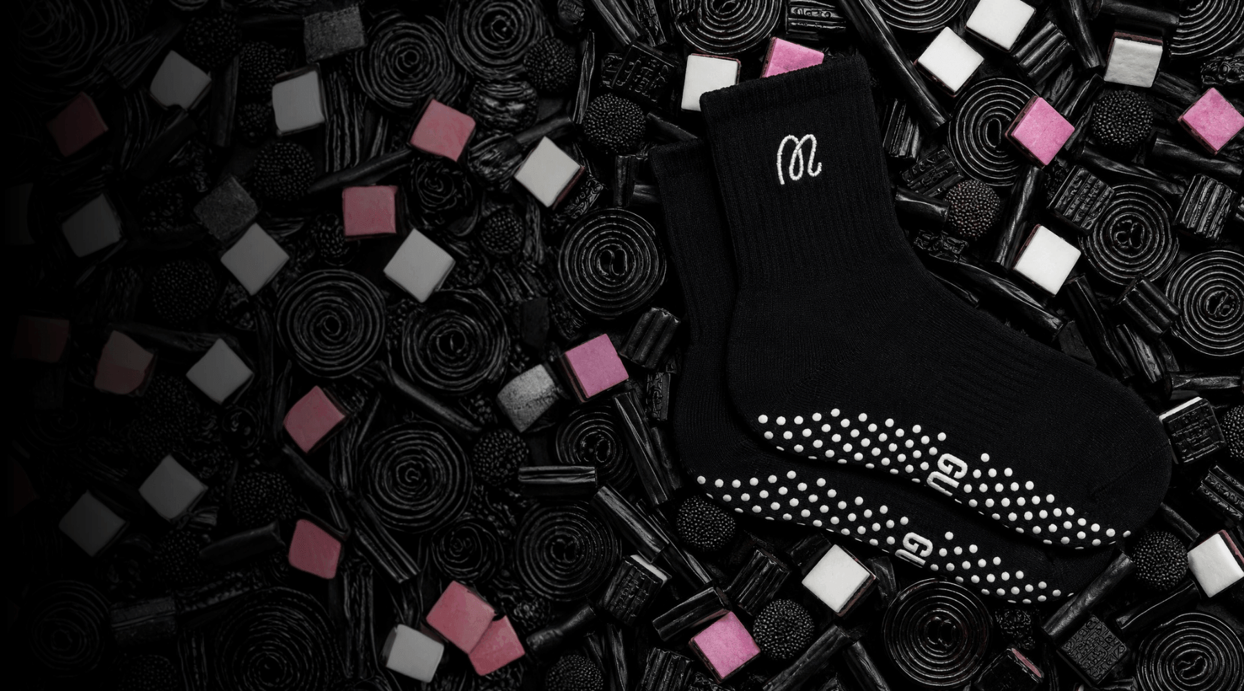 Black GUMMI grip socks on a bed of liqourice allsorts.