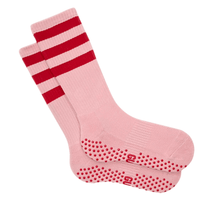 Pink grip socks with red stripes and textured sole on a white background