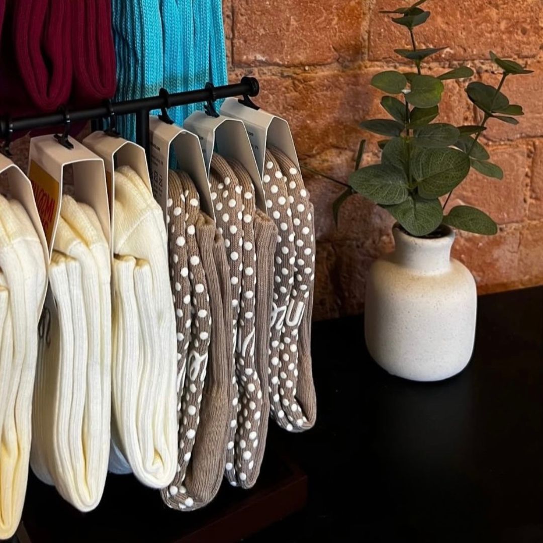 A set of GUMMI pilate grip socks hanging in a pilates studio.