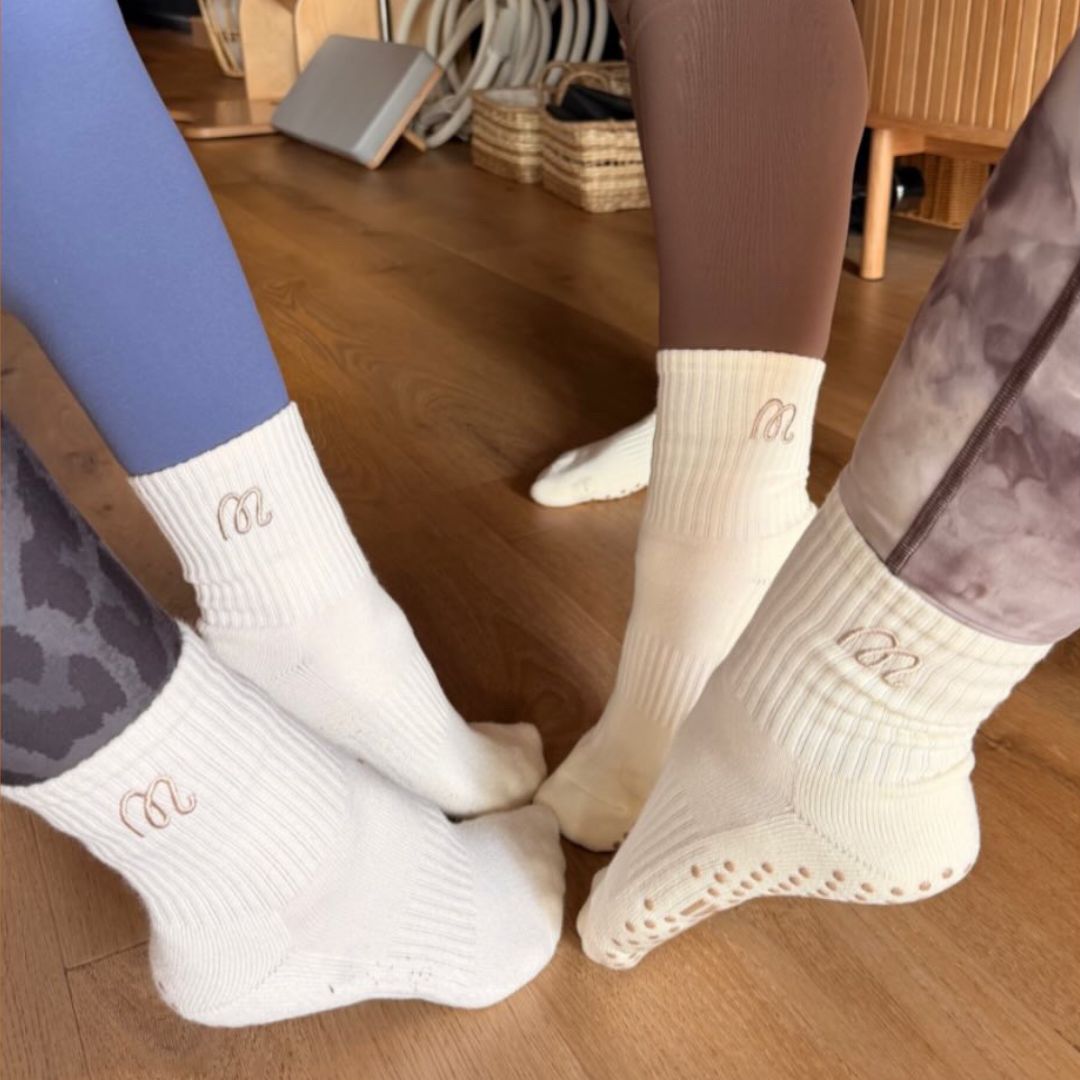Four people all wearing GUMMI socks at pilates.