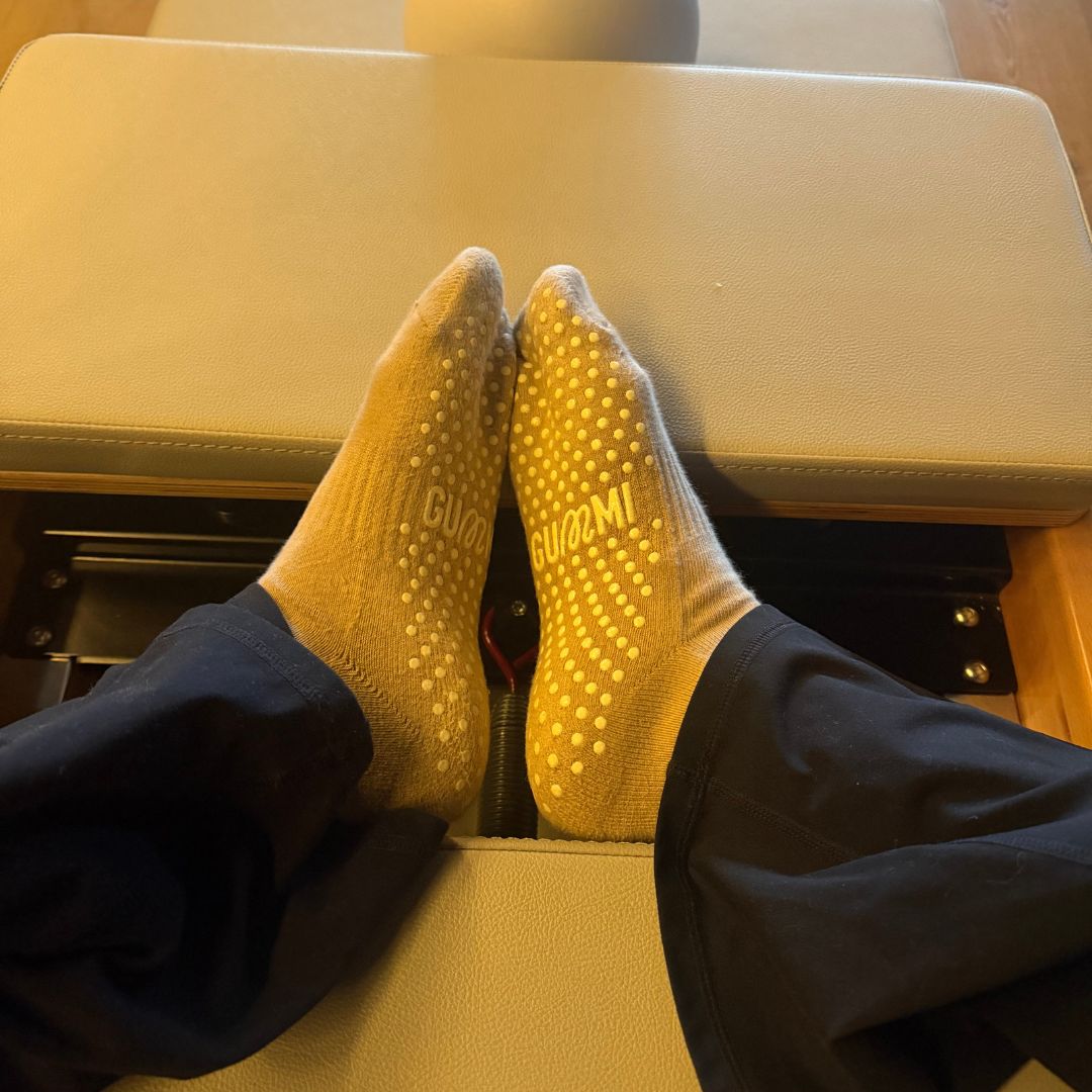 Feet wearing brown grip socks with GUMMI logos