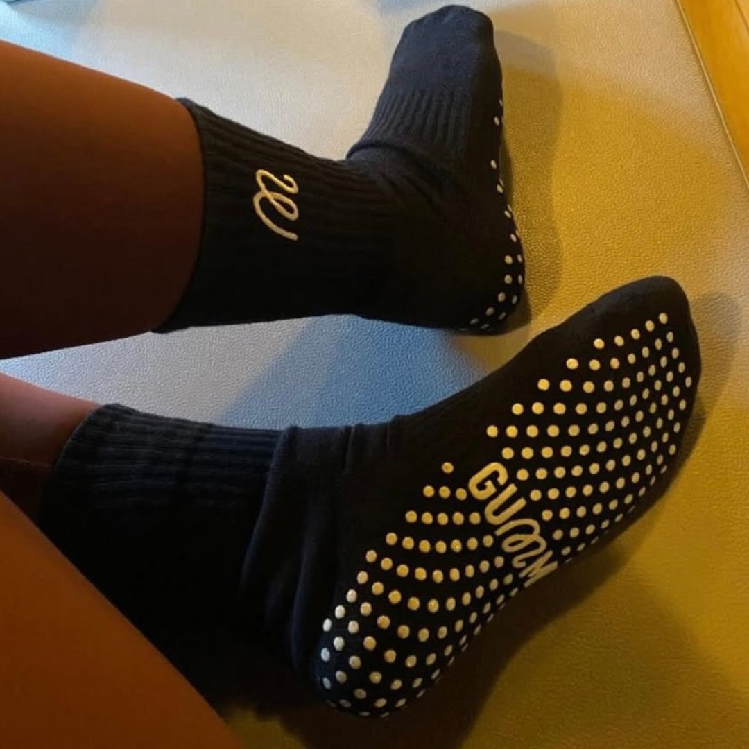 Black grip socks socks on a reformer bed.